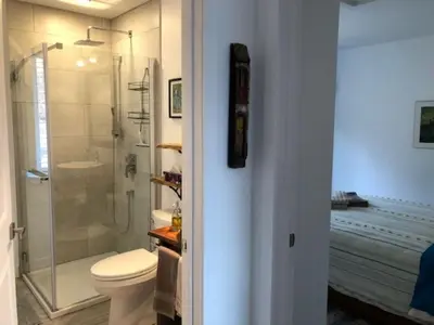 a bathroom with a toilet and a glass shower at Rooms in peaceful nature settings in Sutton