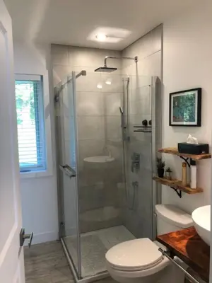 a bathroom with a shower with a toilet and a sink at Rooms in peaceful nature settings in Sutton