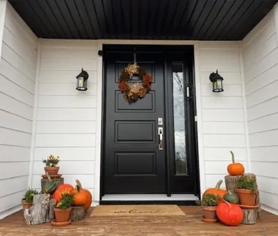 a black door on a house with pumpkins on the porch at Rooms in peaceful nature settings in Sutton