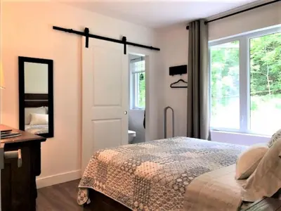 a bedroom with a bed and a mirror at Rooms in peaceful nature settings in Sutton