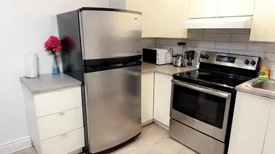 a kitchen with a stainless steel refrigerator and a stove at Spacious basement apartment in Montréal