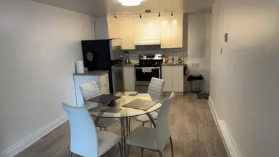 a kitchen and dining room with a table and chairs at Spacious basement apartment in Montréal