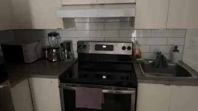 a kitchen with a stove and a sink at Spacious basement apartment in Montréal