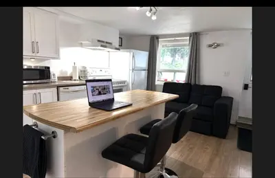 a kitchen with a table with a laptop on it at La Suite Centre-ville Saint-Georges in Saint-Georges
