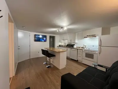 a kitchen with a couch and a counter in a room at La Suite Centre-ville Saint-Georges in Saint-Georges