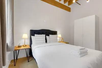 a bedroom with a bed with white sheets and pillows at The Little Prince Rooms-Old Montreal in Montréal