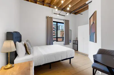 a bedroom with a white bed and a couch at The Little Prince Rooms-Old Montreal in Montréal