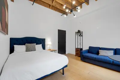 a bedroom with a bed and a blue couch at The Little Prince Rooms-Old Montreal in Montréal