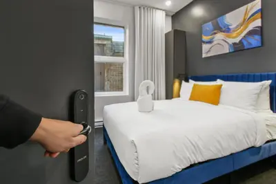 a person opening a door to a bedroom with a bed at Lift Hotel in Montréal