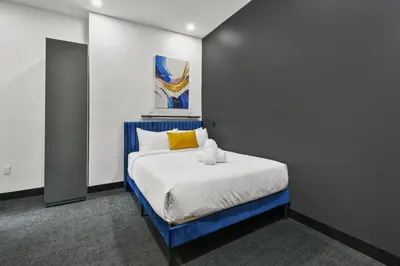 a bedroom with a blue and white bed with a yellow pillow at Lift Hotel in Montréal