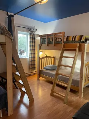 a bunk bed room with two bunk beds and a ladder at Auberge Le Wagon in Wotton