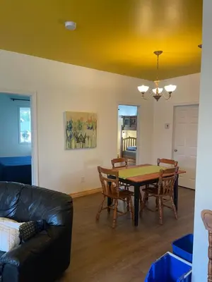 a living room with a table and chairs and a couch at Auberge Le Wagon in Wotton
