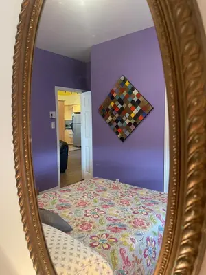 a mirror with a bed in a purple bedroom at Auberge Le Wagon in Wotton