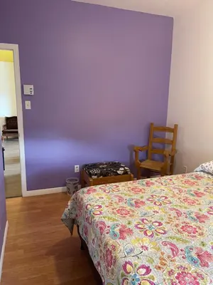 a bedroom with a bed and a purple wall at Auberge Le Wagon in Wotton
