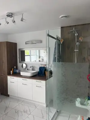 a bathroom with a glass shower and a sink at Luna's Room in Longueuil