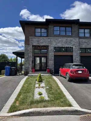 a red car parked in front of a house at Luna's Room in Longueuil