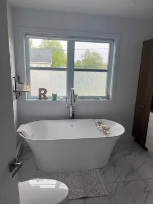 a white bath tub in a bathroom with a window at Luna's Room in Longueuil
