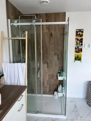 a shower with a glass door in a bathroom at Luna's Room in Longueuil