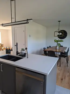 a kitchen with a sink and a table with chairs at 4 bedrooms New House in Farnham