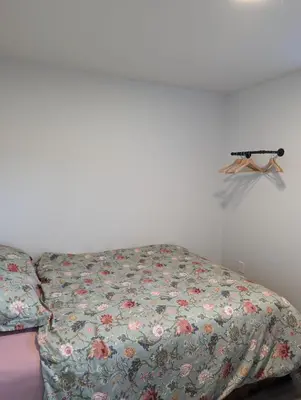 a bed with a floral comforter in a room at 4 bedrooms New House in Farnham
