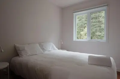 a white bed in a white room with a window at Chalet 1 OST Shefford in Shefford