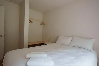 a white bed with two towels on top of it at Chalet 5 OST Shefford in Shefford