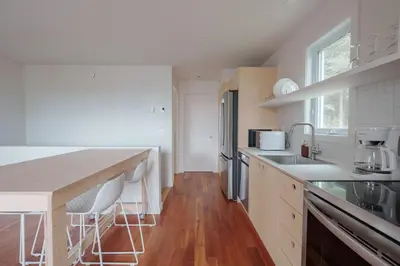 a kitchen with white counters and a wooden floor at Chalet 6 OST Shefford in Shefford