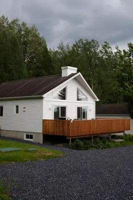 a large white house with a wooden deck at Chalet 3 OST Shefford in Shefford