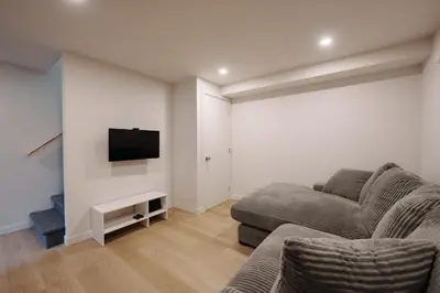 a living room with a couch and a flat screen tv at Chalet 3 OST Shefford in Shefford