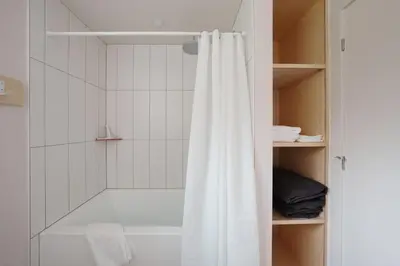 a shower with a white shower curtain in a bathroom at Chalet 3 OST Shefford in Shefford