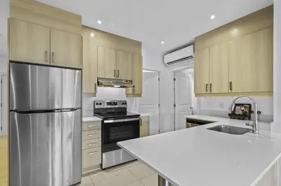a kitchen with a stainless steel refrigerator and a sink at Renovated 2-Bedroom Haven by Jean Talon Market in Montréal