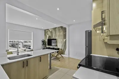 a kitchen with a sink and a living room at Renovated 2-Bedroom Haven by Jean Talon Market in Montréal
