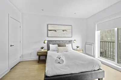 a bedroom with a bed with two towels on it at Renovated 2-Bedroom Haven by Jean Talon Market in Montréal