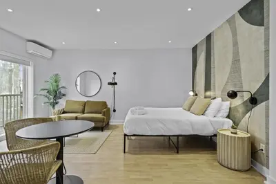 a bedroom with a bed and a couch and a table at Trendy Open-Space Studio by Jean Talon Market in Montréal