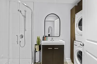 a bathroom with a sink and a washing machine at Trendy Open-Space Studio by Jean Talon Market in Montréal