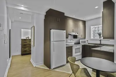 a kitchen with a white refrigerator and a table at Trendy Open-Space Studio by Jean Talon Market in Montréal