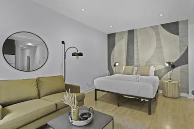 a bedroom with a bed and a couch and a mirror at Trendy Open-Space Studio by Jean Talon Market in Montréal