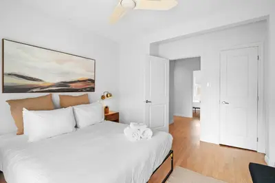 a white bedroom with a large bed with white pillows at Trendy 2-Bedroom Haven by Jean Talon Market in Montréal
