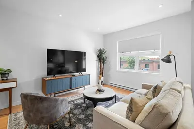 a living room with a couch and a tv at Trendy 2-Bedroom Haven by Jean Talon Market in Montréal