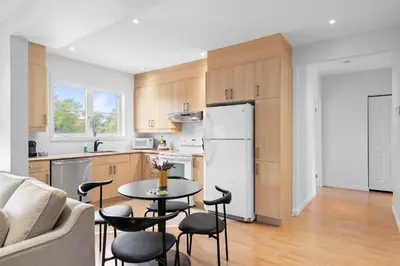 a kitchen with a table and chairs and a refrigerator at Trendy 2-Bedroom Haven by Jean Talon Market in Montréal