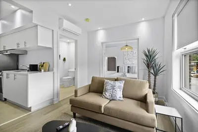 a living room with a couch and a kitchen at Stylish 1-Bedroom Haven by Jean Talon Market in Montréal