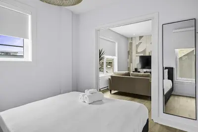 a white room with a bed and a mirror at Stylish 1-Bedroom Haven by Jean Talon Market in Montréal