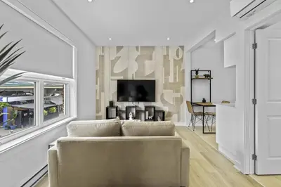 a living room with a couch and a tv at Stylish 1-Bedroom Haven by Jean Talon Market in Montréal