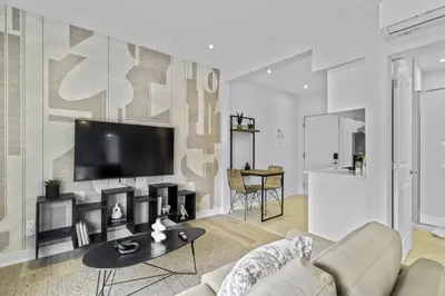 a living room with a couch and a tv on a wall at Stylish 1-Bedroom Haven by Jean Talon Market in Montréal