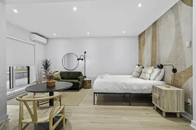a bedroom with a bed and a table and a couch at Stylish Open-Space Studio by Jean Talon Market in Montréal