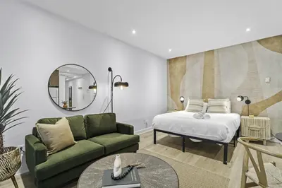 a living room with a bed and a green couch at Stylish Open-Space Studio by Jean Talon Market in Montréal