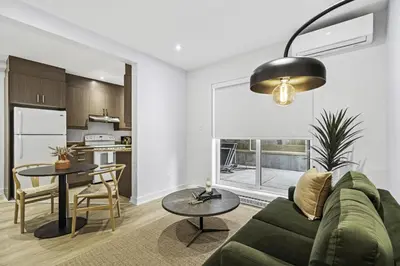 a living room with a green couch and a table at Stylish Open-Space Studio by Jean Talon Market in Montréal