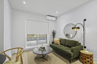 a living room with a green couch and a table at Stylish Open-Space Studio by Jean Talon Market in Montréal