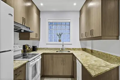 a kitchen with wooden cabinets and a sink and a window at Stylish Open-Space Studio by Jean Talon Market in Montréal