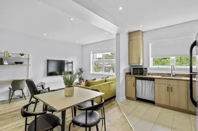 a kitchen and living room with a table and chairs at Stylish 2 Bedroom Haven by Jean Talon Market in Montréal
